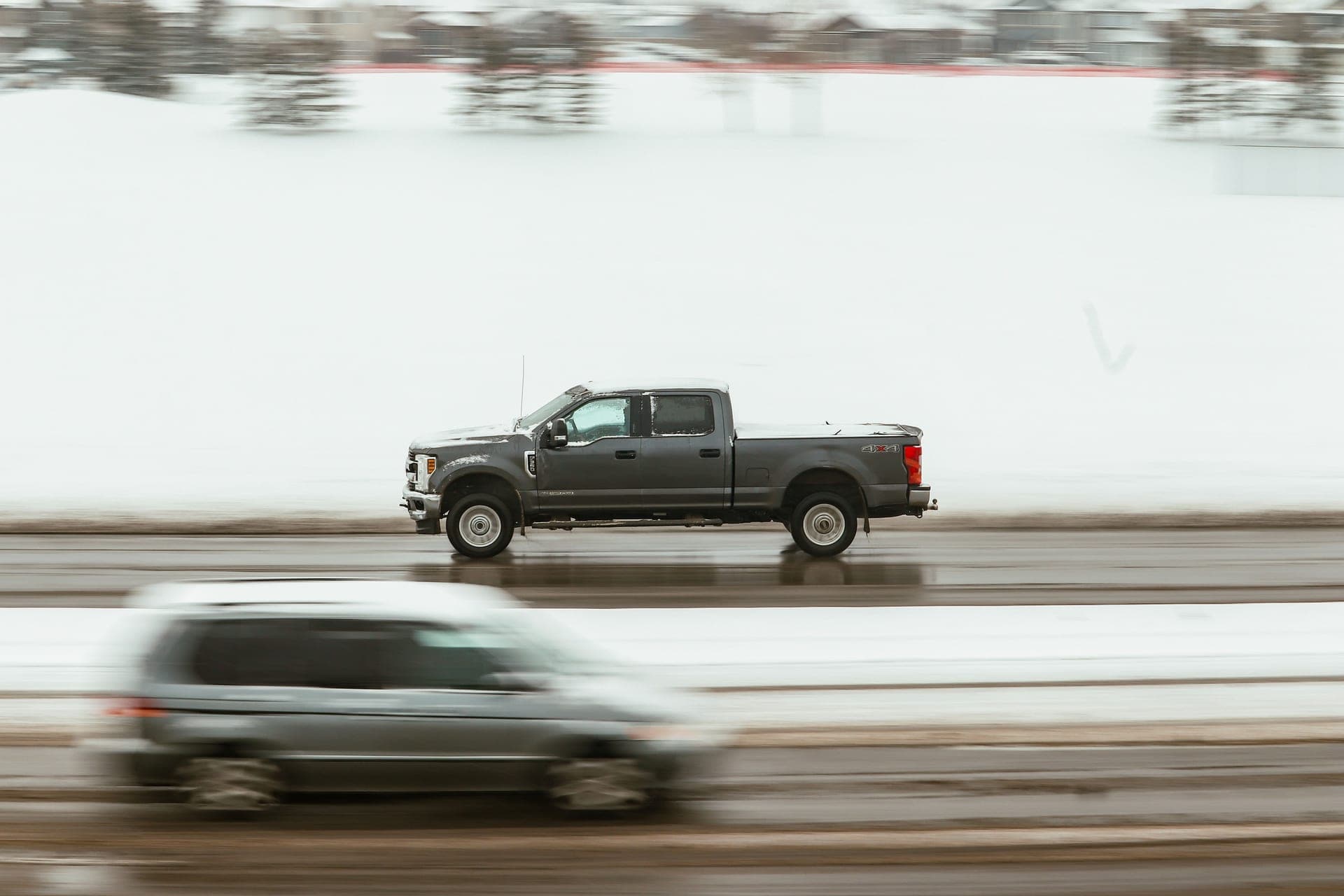 A pickup truck speeds through a snowy highway in Calgary, capturing motion and winter ambiance