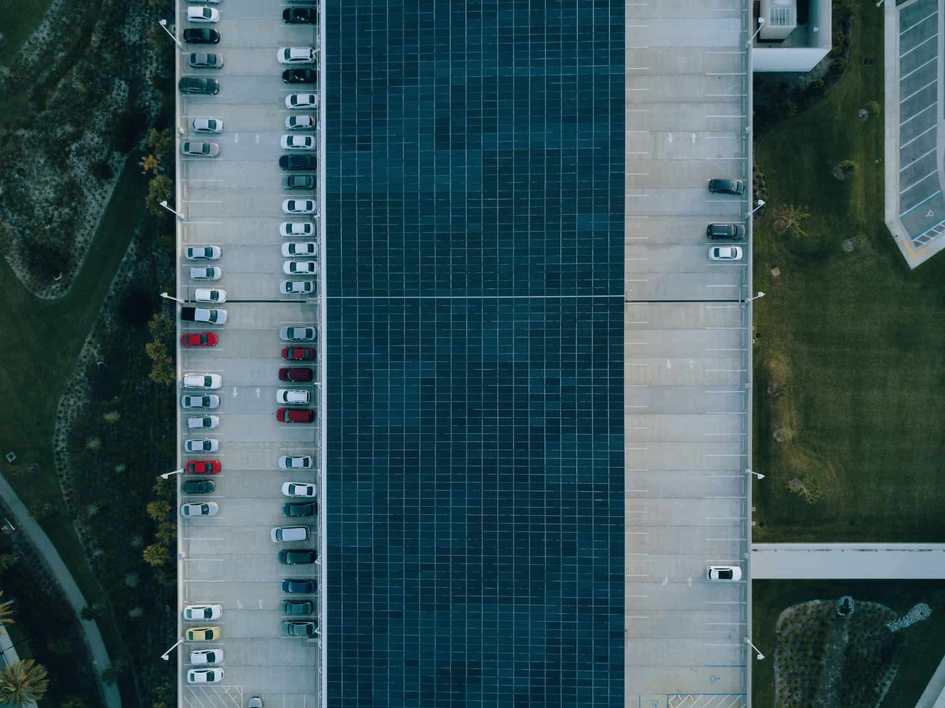 Top view of a parking lot with cars and solar panels