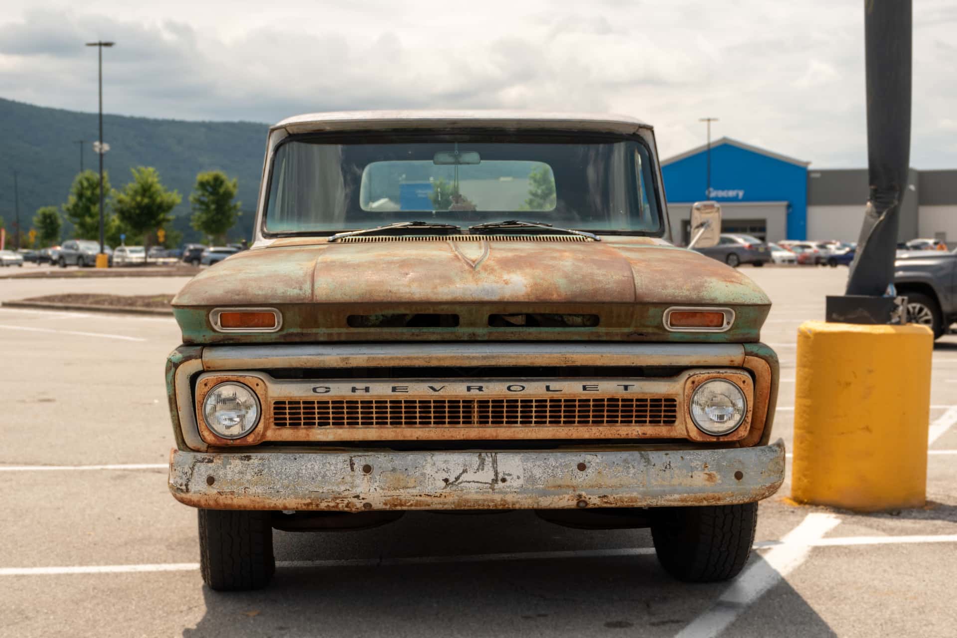 Front view of a vintage rusty Chevrolet truck parked outdoors