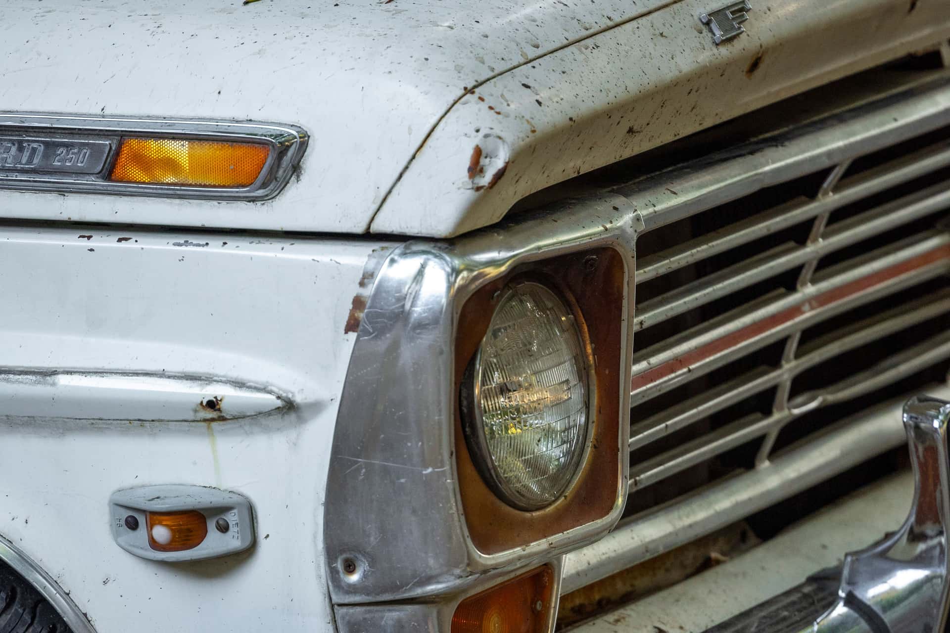 Detail view of a vintage Ford truck grille with faded paint and rust marks