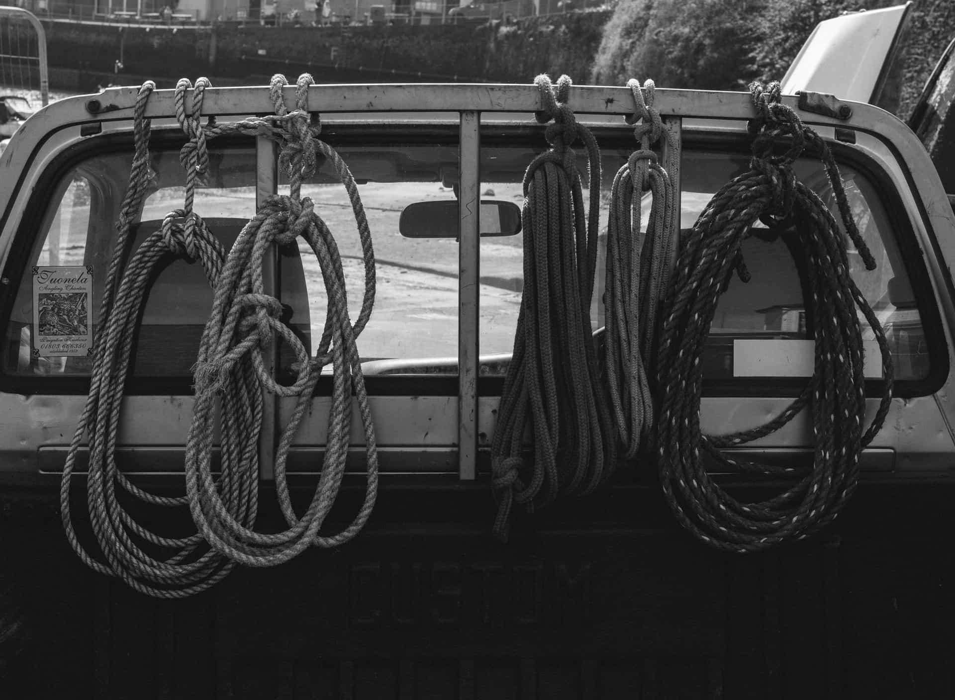 Artistic black and white photo of ropes hanging on an old pickup truck
