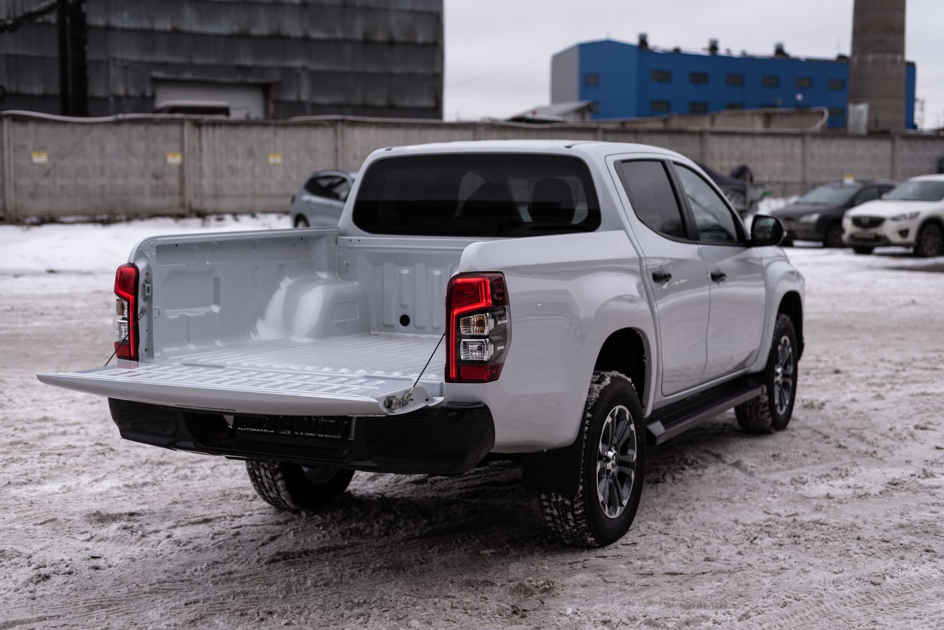 White pickup truck parked in a snowy industrial area