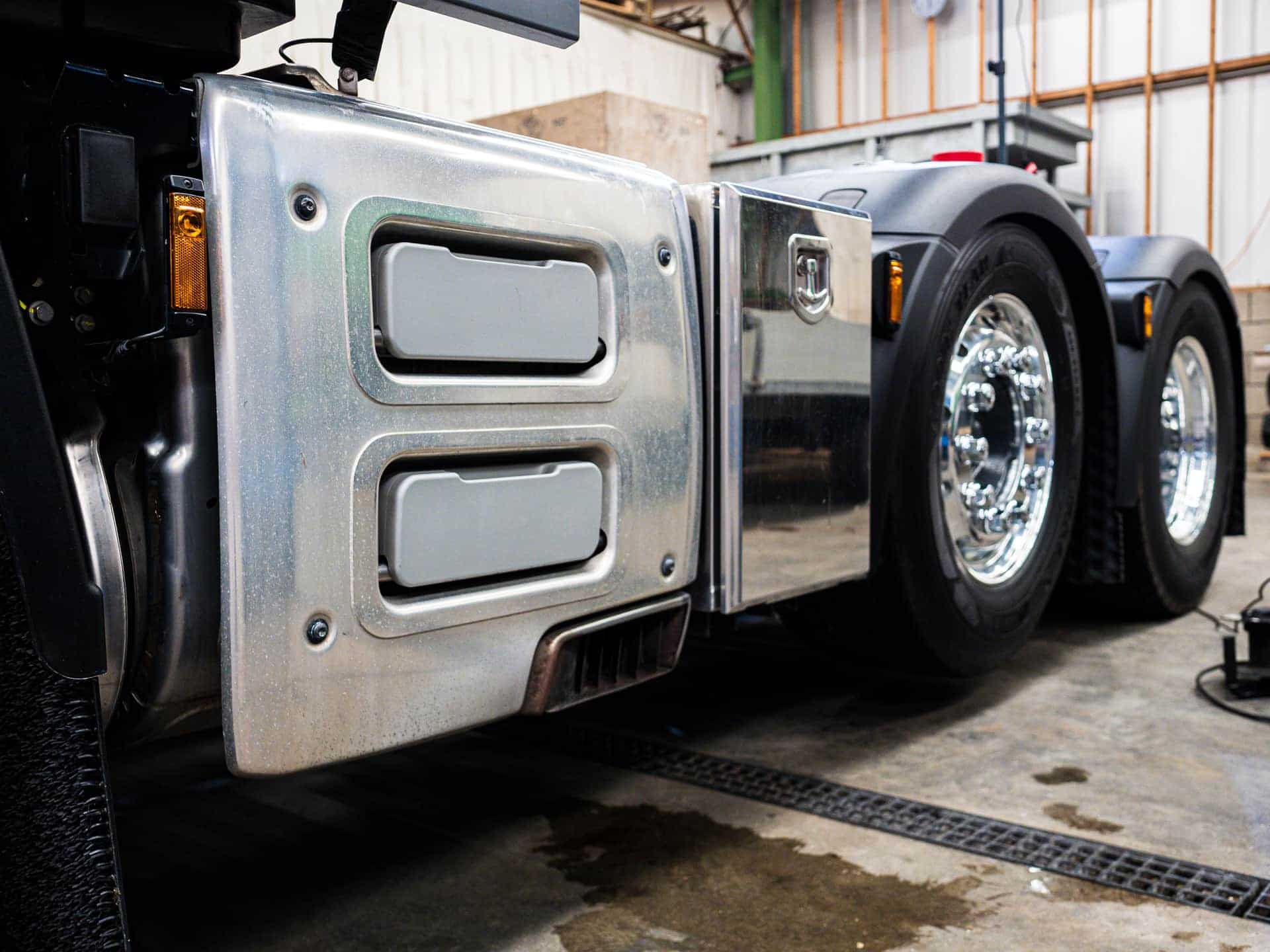 Detailed view of truck wheels and metallic detailing in an indoor workshop setting