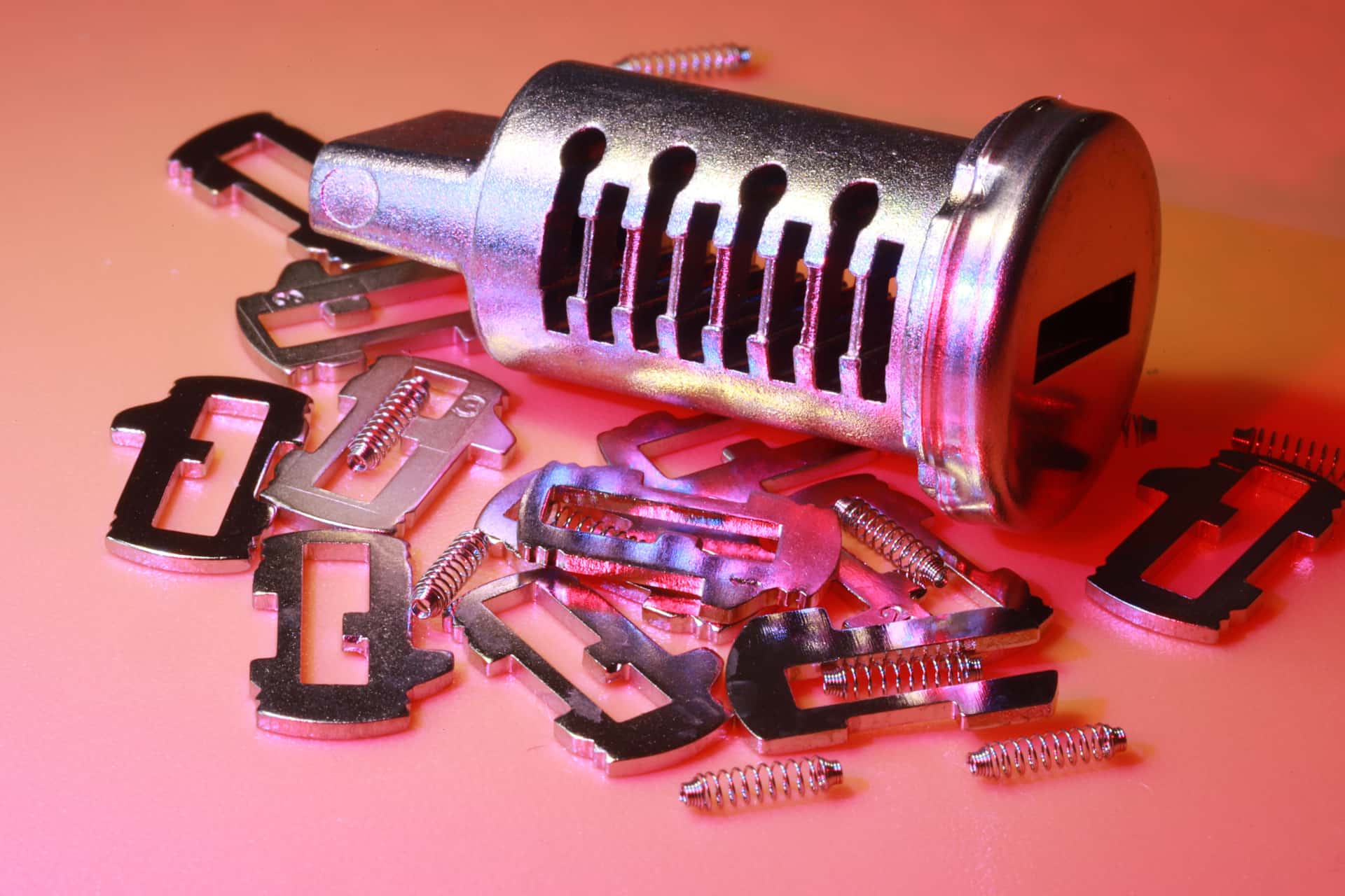 Detailed image of a disassembled lock cylinder and its metal components on a colored surface