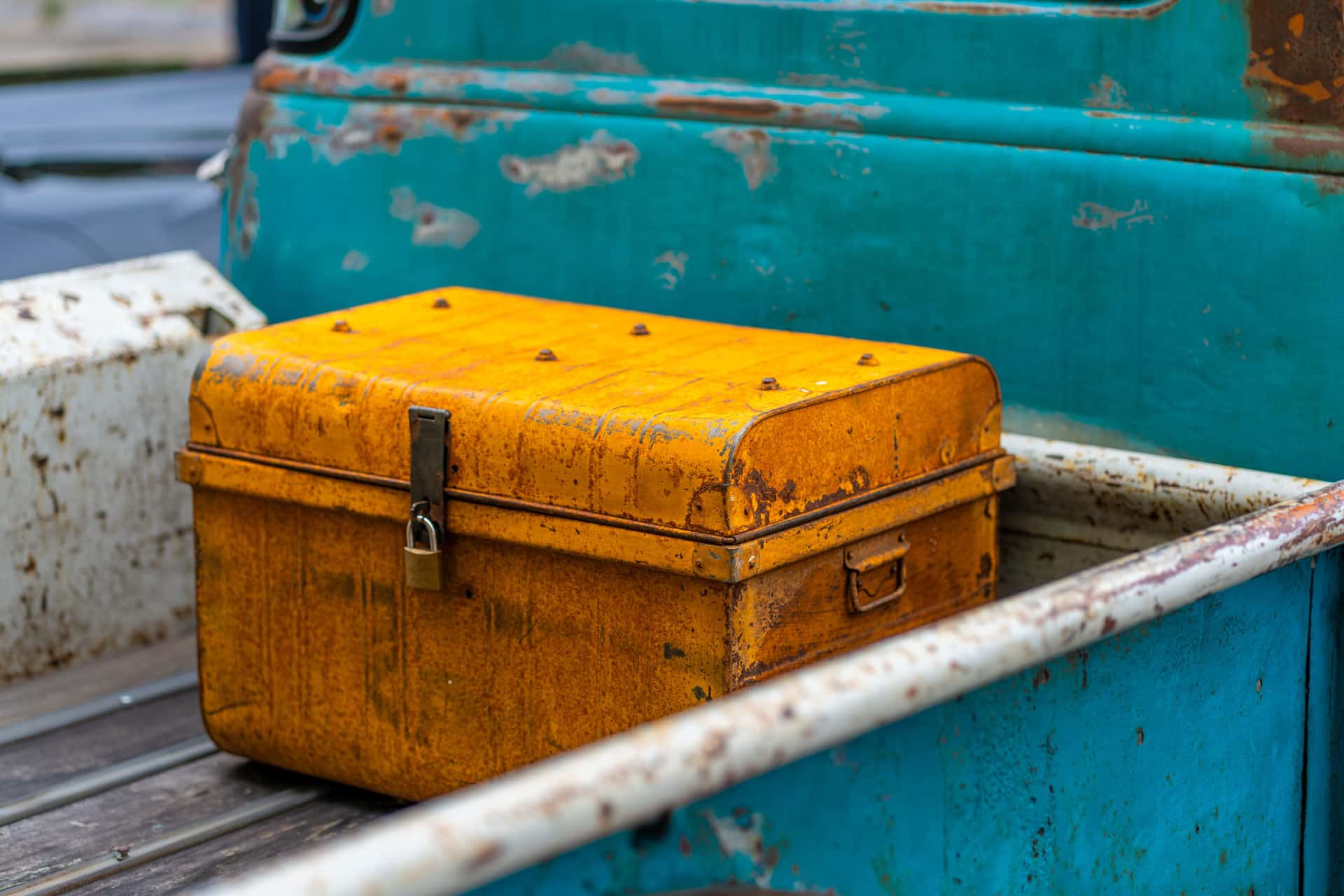 Yellow chest in a vintage truck bed with a weathered, rustic appearance