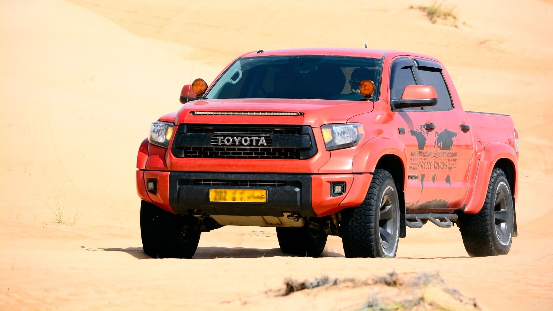 Front view of Toyota Tundra pickup truck navigating a sunny desert landscape