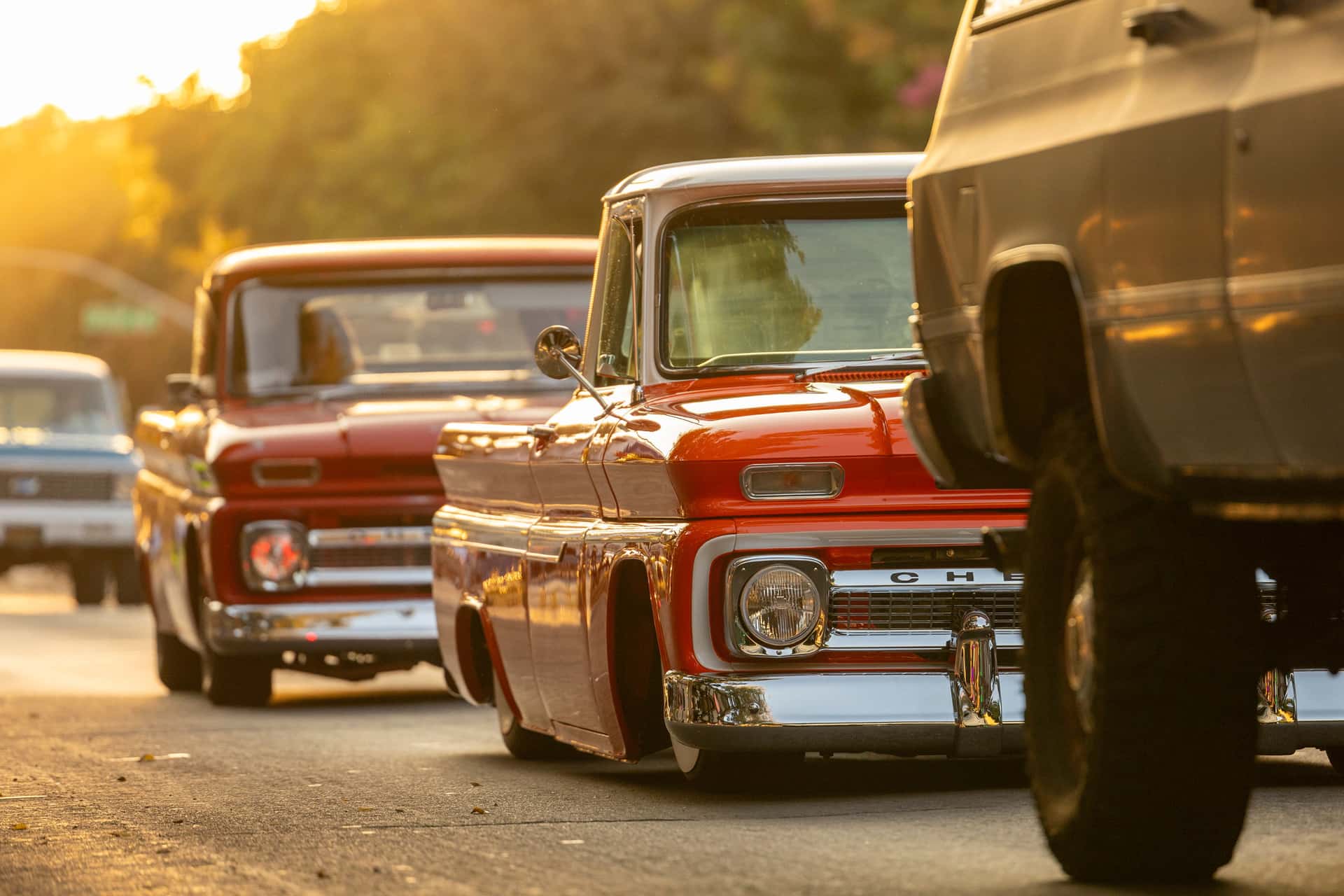 Retro Chevrolet trucks showcased on city streets during a golden sunset